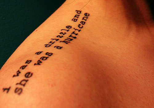 Typewriting quote tattoo design on upper shoulder