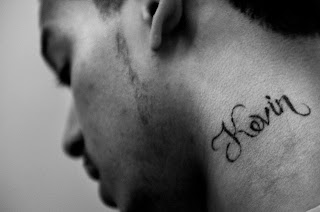 Tatuagem com nome Kevin no pescoço