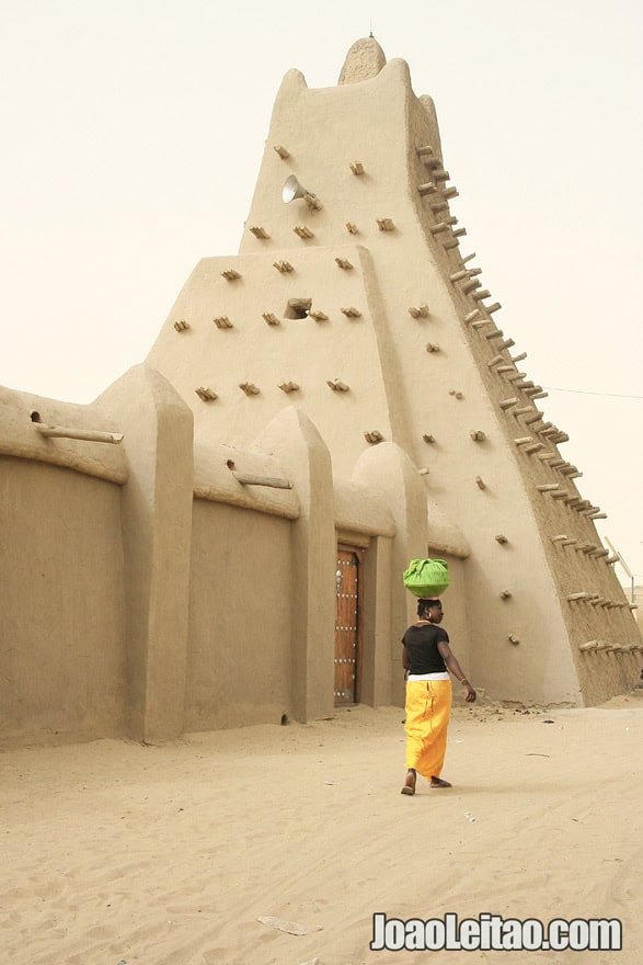 Woman walking aside Sankore Mosque - Travel to Timbuktu
