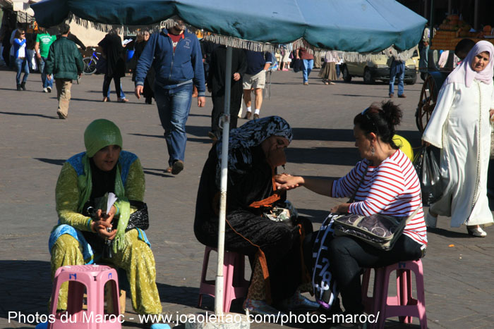 Femmes qui font de la peinture de henné sur la place Jamaâ El Fna à Marrakech