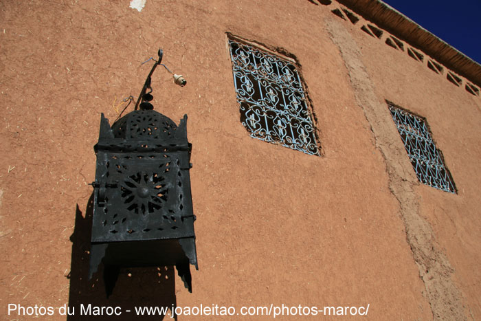 Lampe décorée et mur de boue dans le oasis de Fint