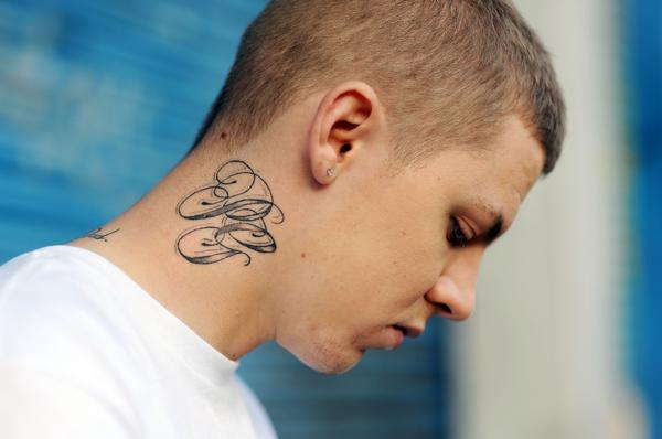 Initials tattoo on the side of the neck