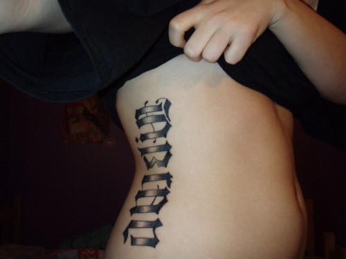 Name tattoo idea in gothic font on the side ribs