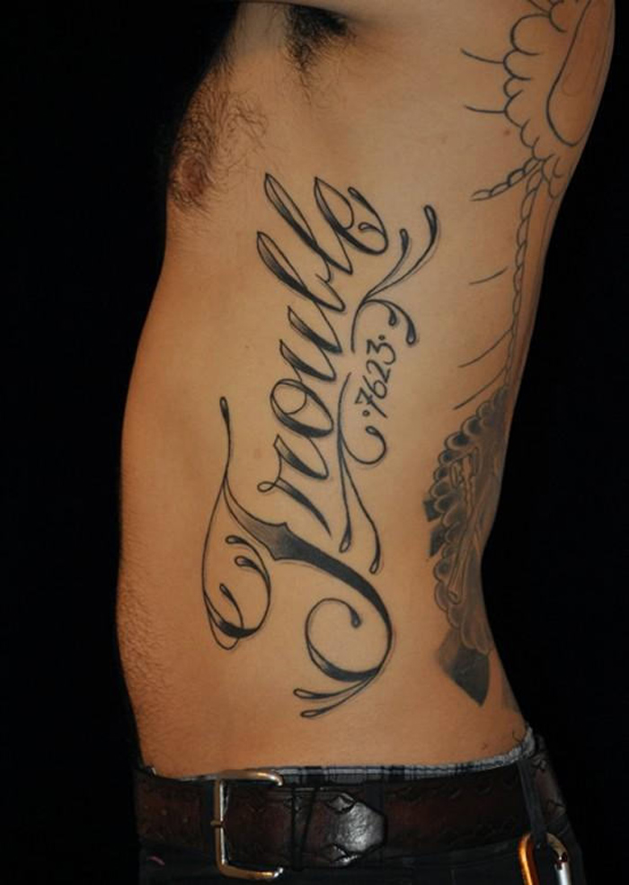 Upward script tattoo design on left rib for man