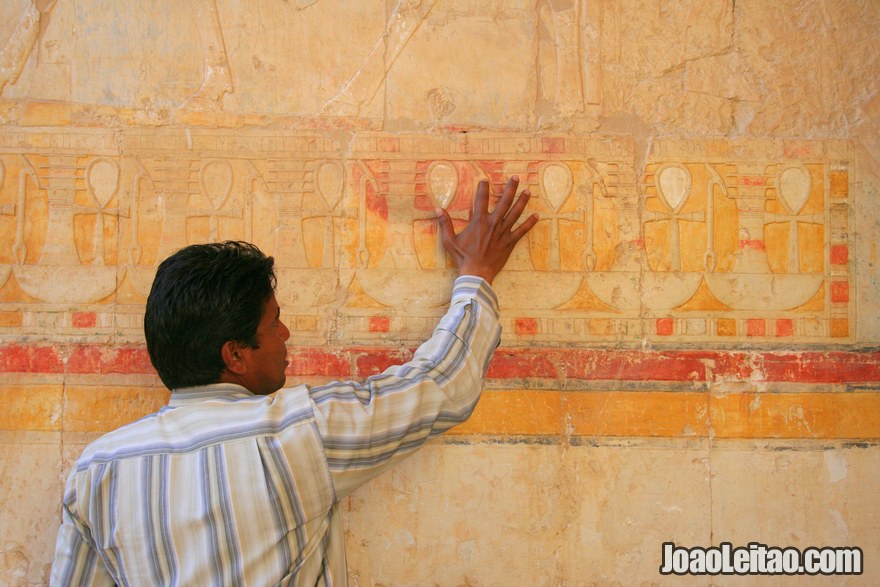 Guia a explicar o significado das figuras e hieróglifos na parede do Templo de Hatshepsut