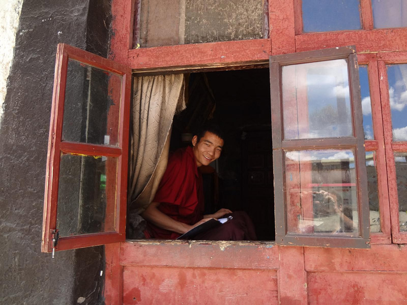 Um monge tibetano à entrada do Mosteiro Tashilhunpo