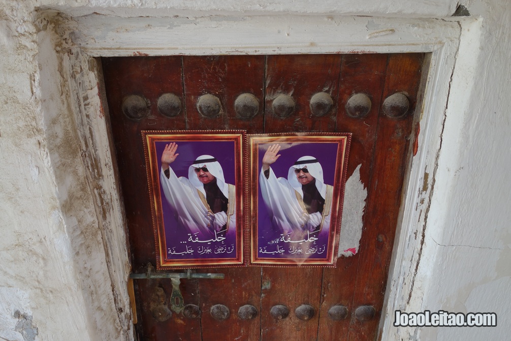 Posters colados numa porta de madeira no bairro histórico da ilha de Murharraq no Barém