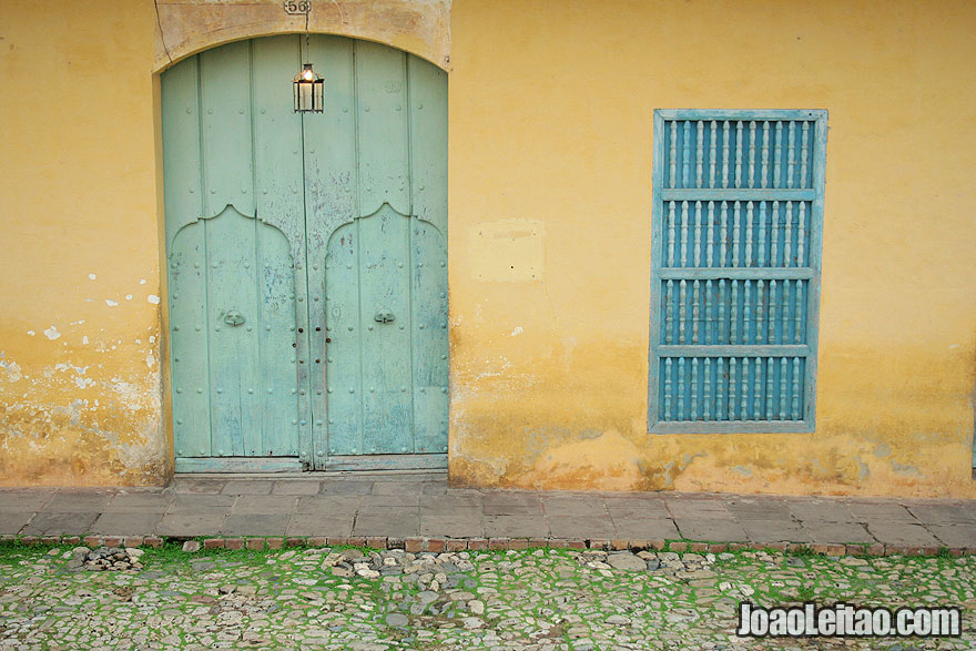Wooden green door and blue window with yellow buildin in Trinidad