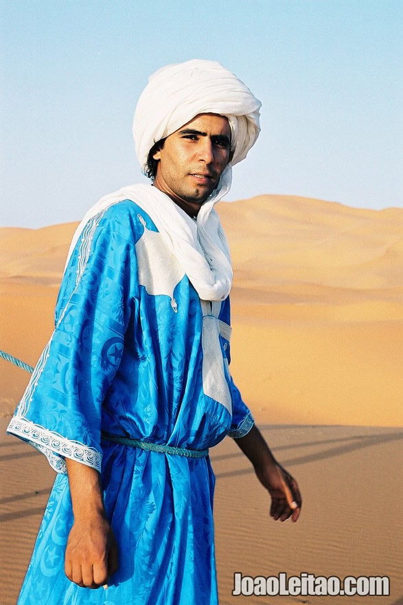 Young man crossing the Erg Chebbi Dunes in Sahara Desert, Morocco