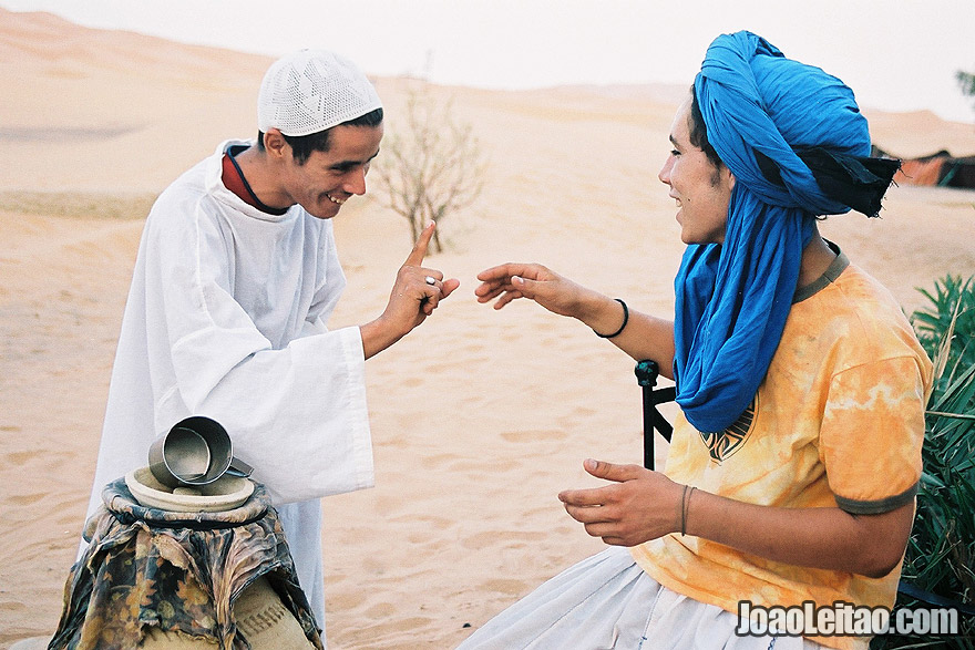 Photo of young men talking to each other in Erg Chebbi Dunes, Morocco