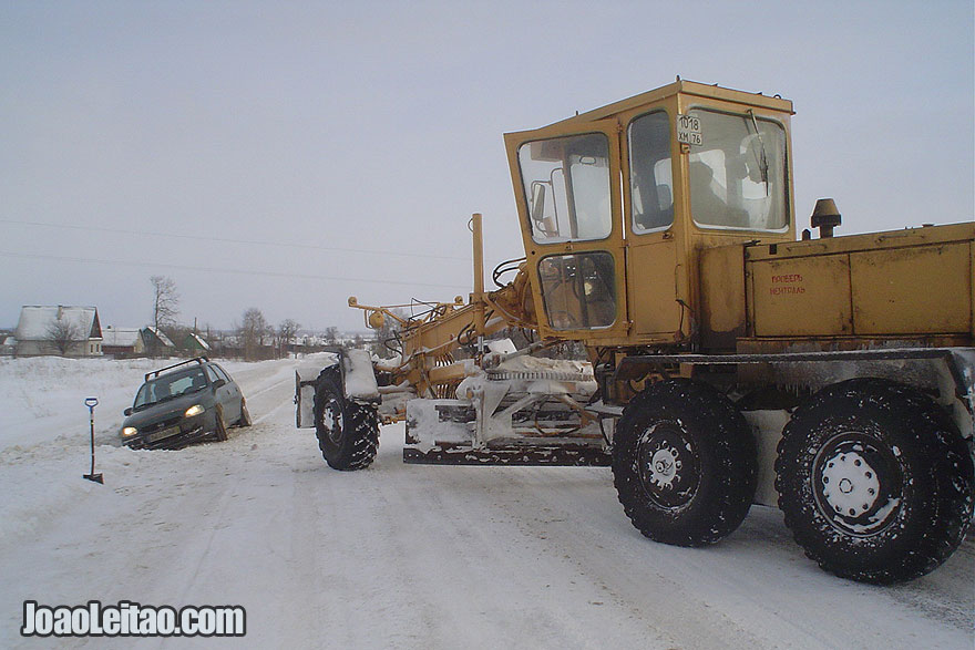 My car being towed by a road graver