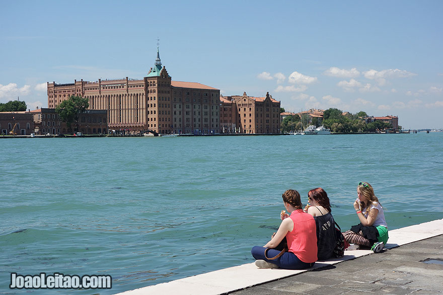 Girls overlooking Venice canals with Hotel Hilton Molino Stucky Venice located on Giudecca Island