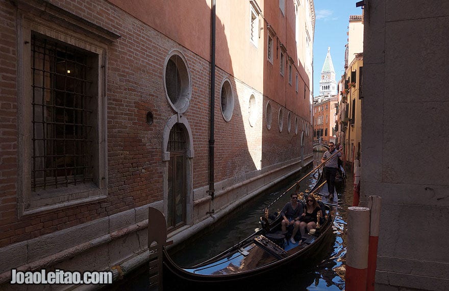 Venice narrow canal with tourist on a gondola ride