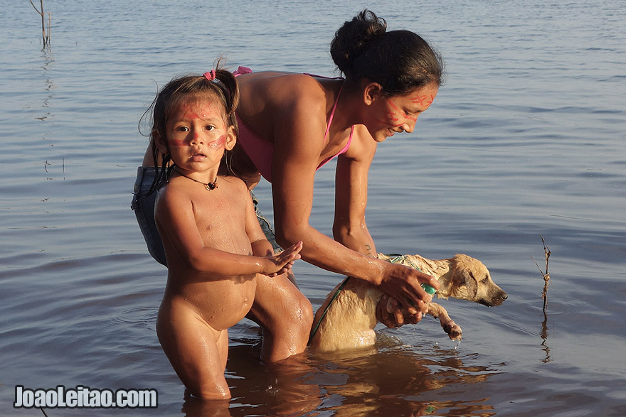 Indigenous woman giving dog a bath in Rio Negro river